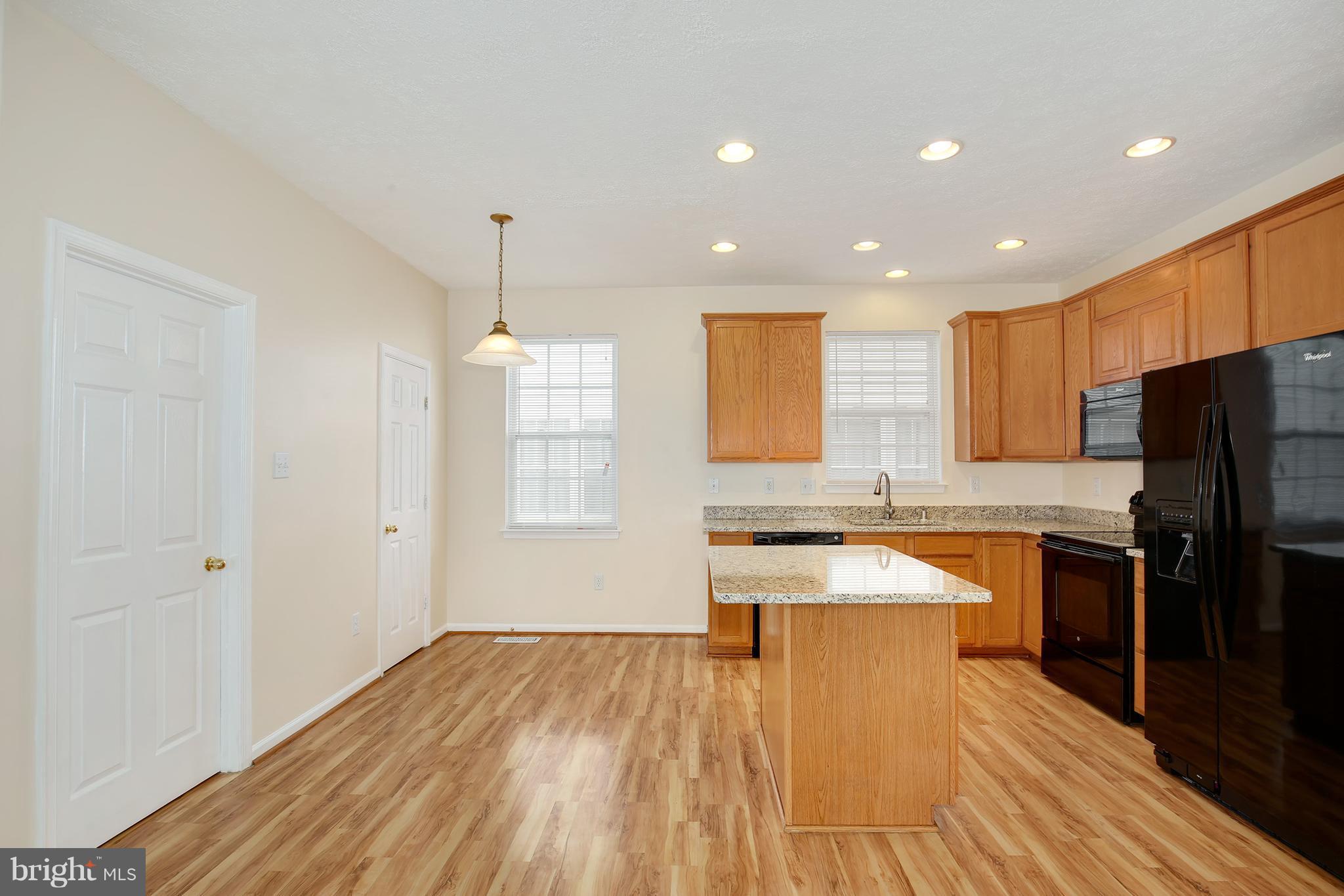 718 Luke Road Baltimore, MD 21220 - Photo 8 of 30 a large kitchen with stainless steel appliances granite countertop a sink stove and refrigerator