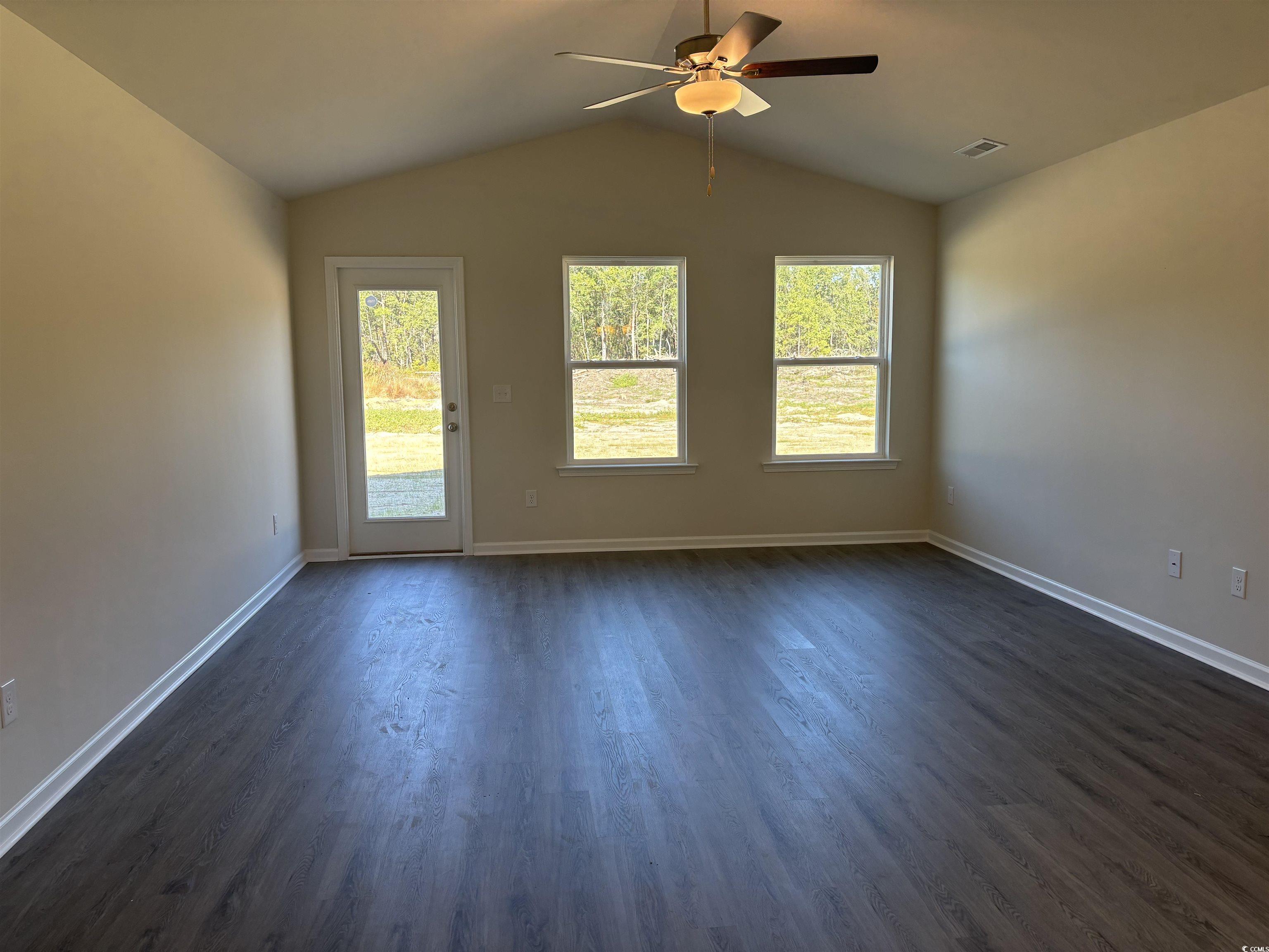 1110 Oscar Road Little River, SC 29566 - Photo 4 of 6 Unfurnished living room featuring healthy amount of natural light, dark wood finished floors, lofted ceiling, and a ceiling fan