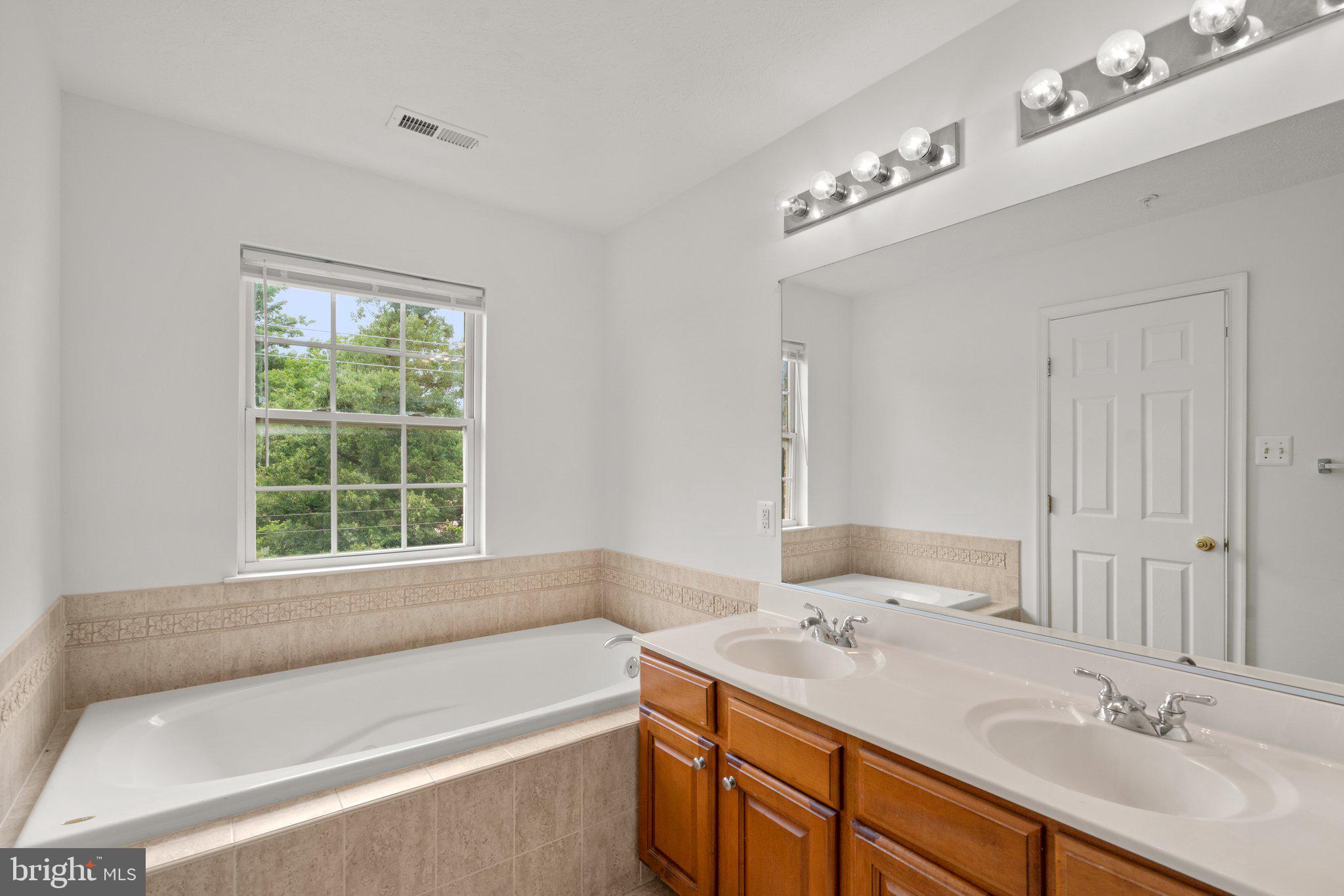 887 Middle River Road Middle River, MD 21220 - Photo 23 of 42 a bathroom with a tub sink and mirror