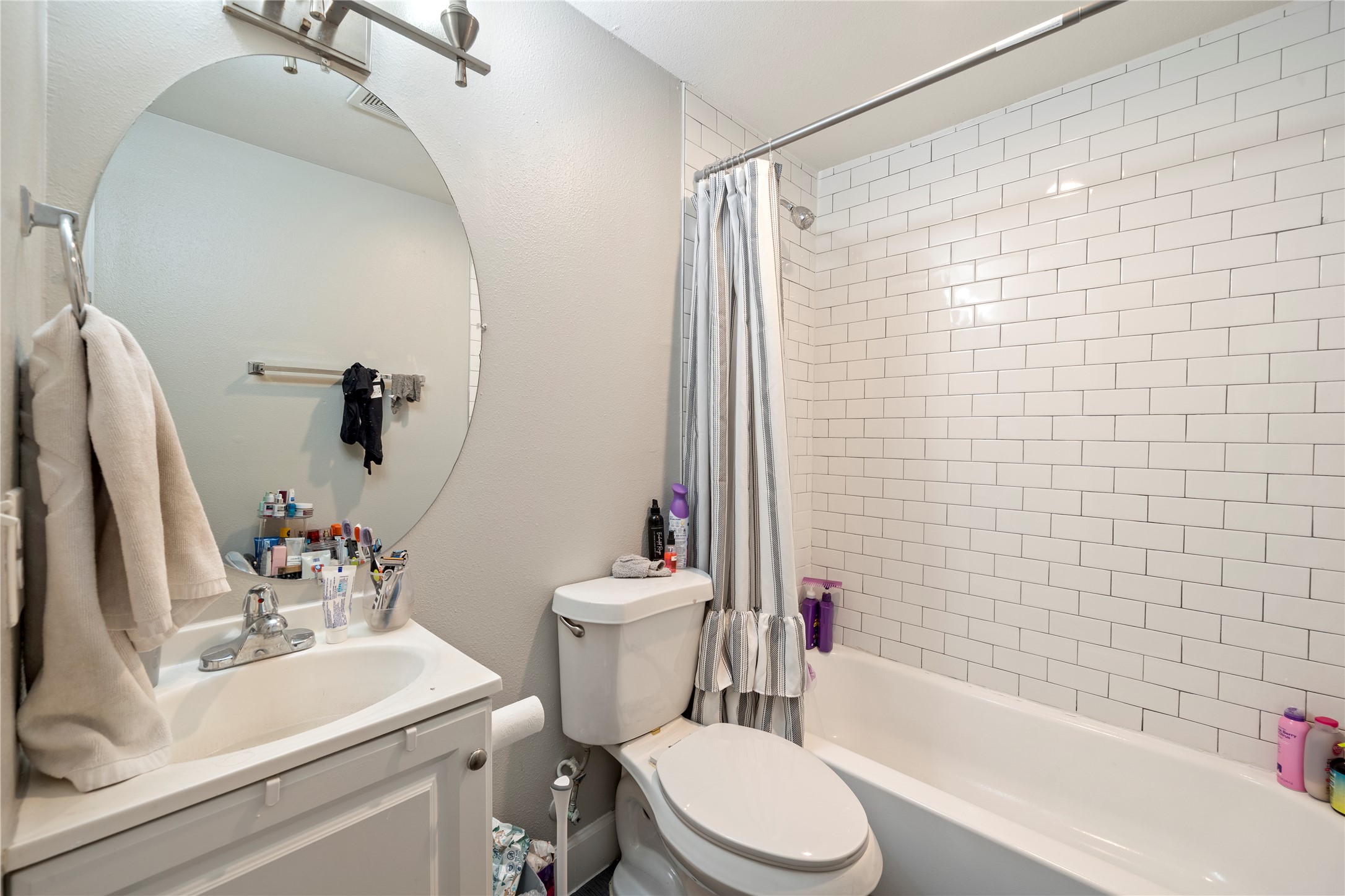 201 West 31st Street, Unit E Austin, TX 78705 - Photo 3 of 16 A well-appointed bathroom features subway tile surrounding the tub, creating a clean and timeless aesthetic.