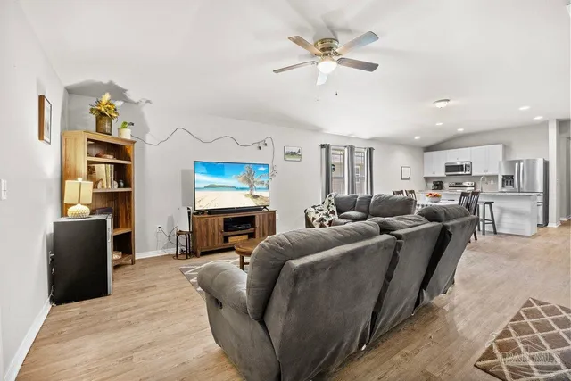 a living room with furniture a fireplace and a flat screen tv
