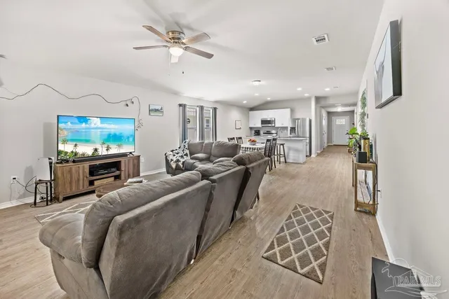 a living room with furniture a flat screen tv and a chandelier