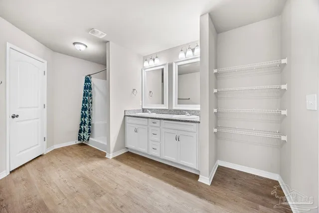 a spacious bathroom with a granite countertop sink and a mirror