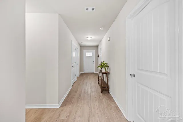 a hallway with wooden floor and a glass door