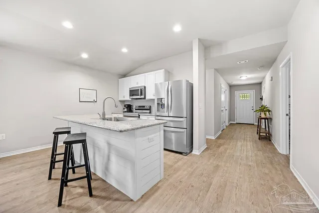 a kitchen with refrigerator cabinets and wooden floor