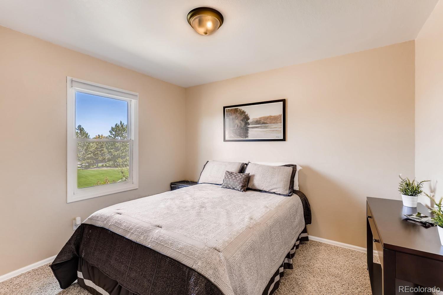 8267 Sweet Water Road Lone Tree, CO 80124 - Photo 15 of 24 a bedroom with a bed and a table
