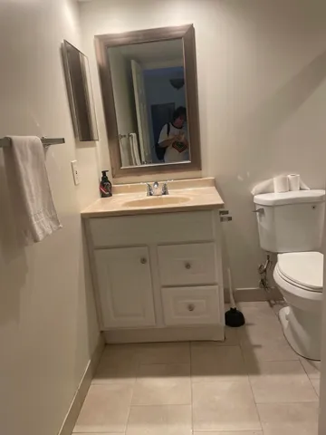 a bathroom with a toilet sink and mirror