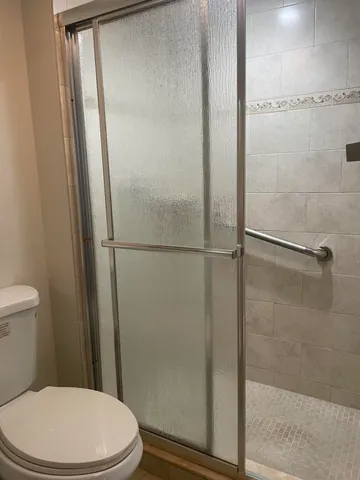 a white toilet sitting next to a shower