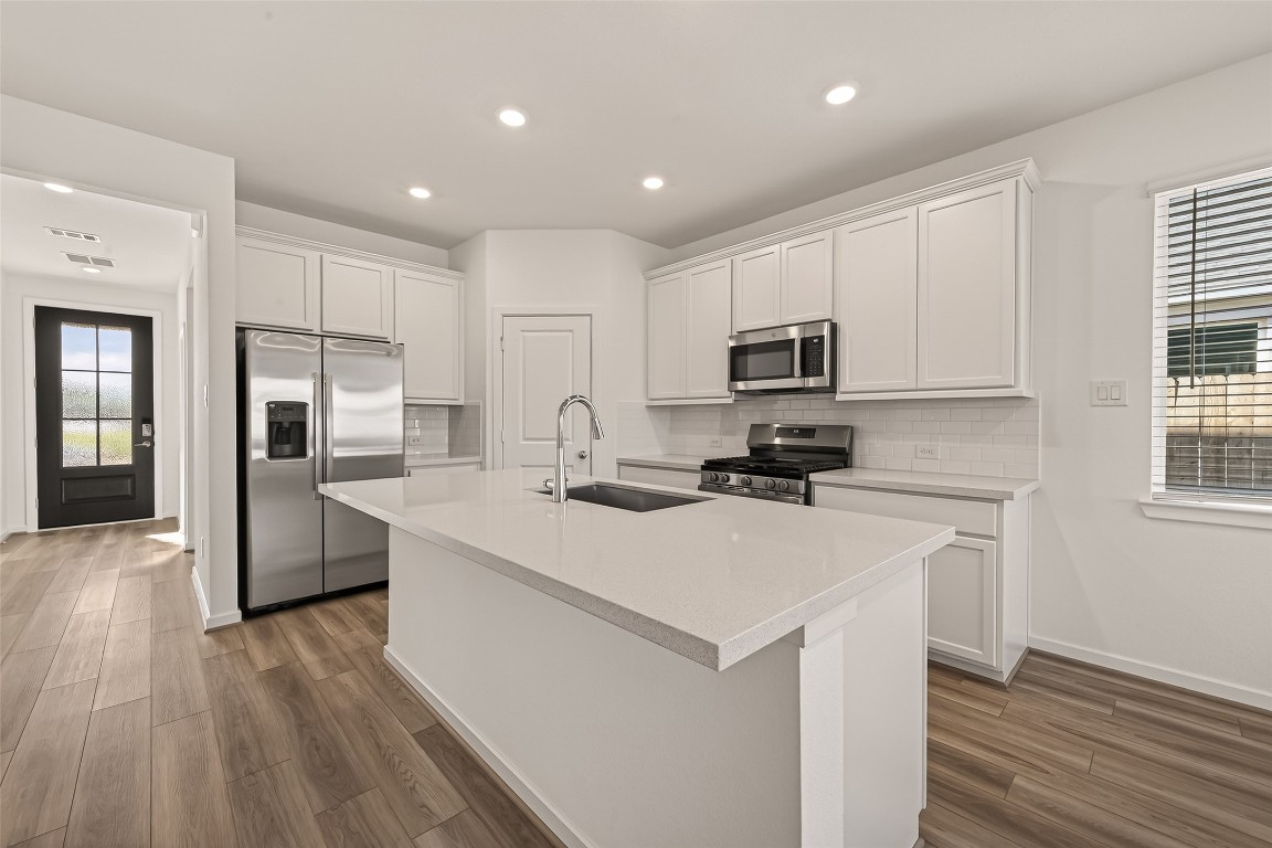 21926 Sam Raburn Drive Tomball, TX 77375 - Photo 12 of 47 a kitchen with a sink a counter top space stainless steel appliances and cabinets