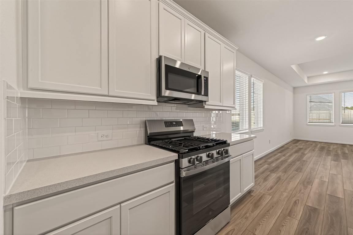 21926 Sam Raburn Drive Tomball, TX 77375 - Photo 14 of 47 a kitchen with stainless steel appliances white cabinets and a stove top oven