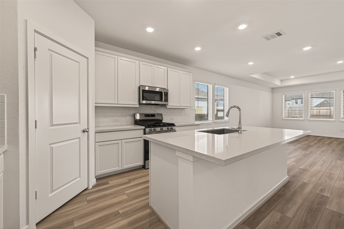 21926 Sam Raburn Drive Tomball, TX 77375 - Photo 16 of 47 a kitchen with kitchen island a sink appliances and cabinets