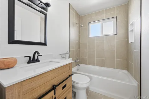 a bathroom with a granite countertop sink toilet and bathtub