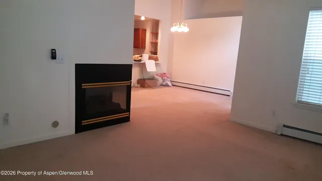 a view of an empty room with a fireplace and a window