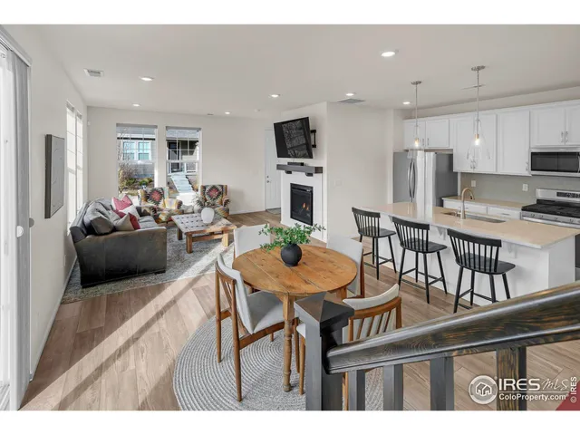 a living room with furniture a flat screen tv and kitchen view
