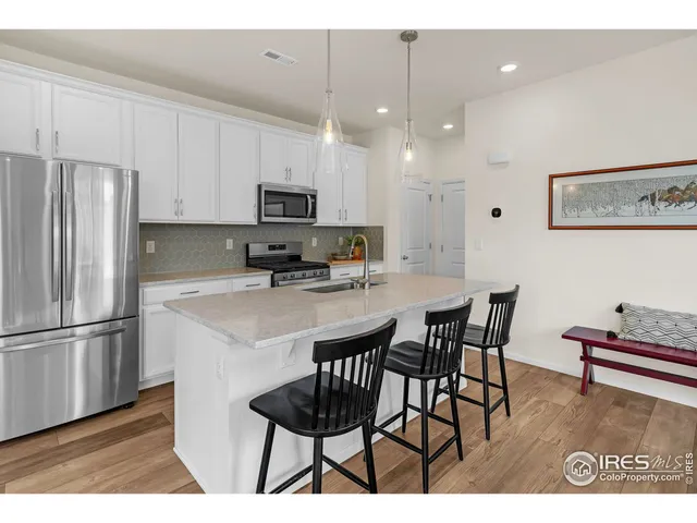 a kitchen with kitchen island granite countertop a table chairs microwave and cabinets