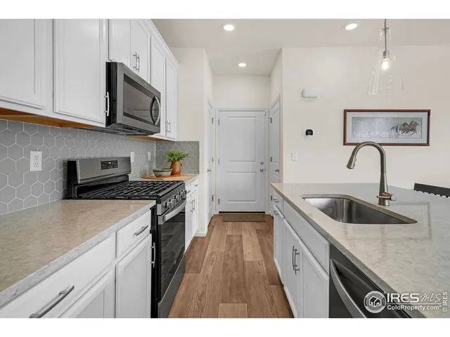 a kitchen with stainless steel appliances granite countertop a sink and a stove