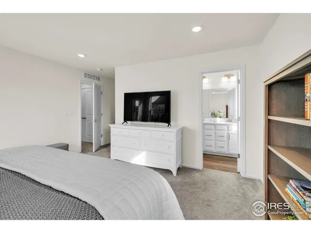 a living room with a flat screen tv and a refrigerator