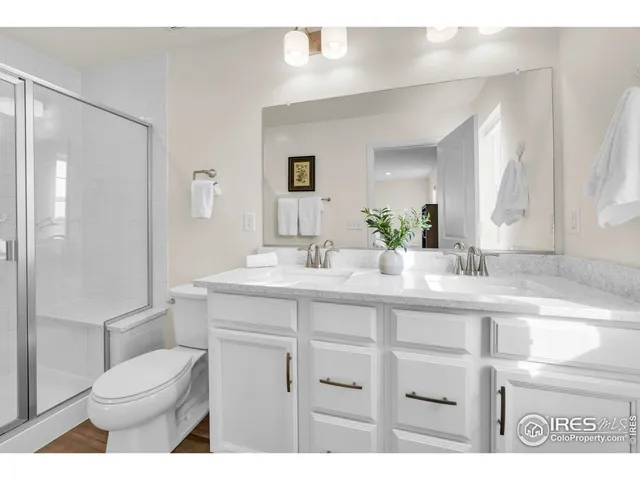 a bathroom with a sink a toilet a mirror and shower