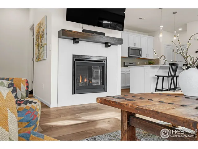 a living room with stainless steel appliances kitchen island furniture and a fireplace