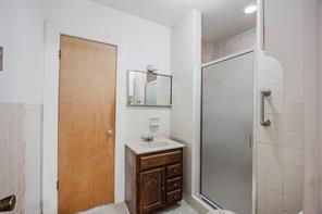 1717 Pipeline Road Cleburne, TX 76033 - Photo 11 of 33 Full bathroom with vanity, a shower stall, and tile walls