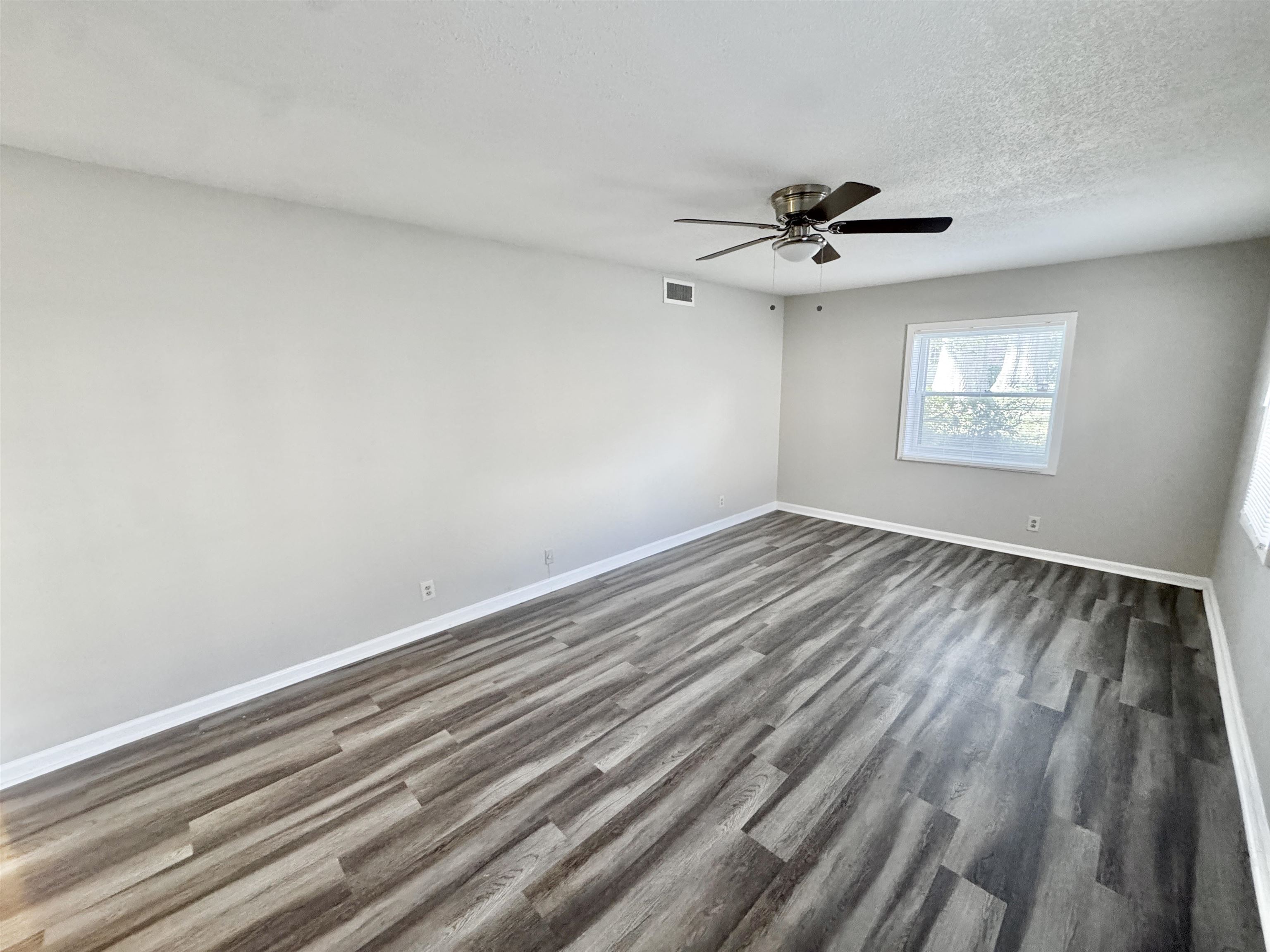 1202 Middle Court, Unit 101 Memphis, TN 38119 - Photo 14 of 24 wooden floor in an empty room with a window
