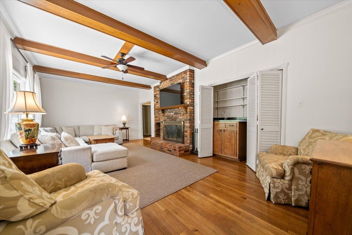1273 Brookfield Road Memphis, TN 38119 - Photo 13 of 40 Living area featuring wood-finish flooring, exposed ceiling beams, wet bar and a brick fireplace