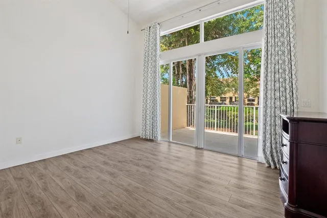 a view of a big room with wooden floor and windows