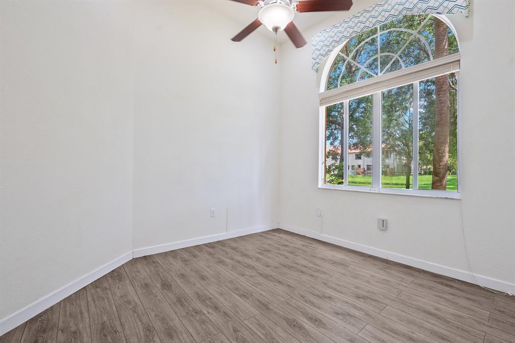 816 West Village Circle, Unit 1 Davie, FL 33325 - Photo 16 of 27 an empty room with wooden floor and windows