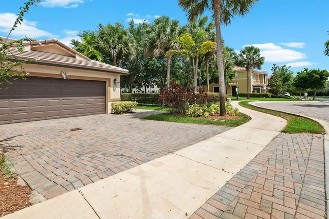 a front view of a house with a yard and potted plants