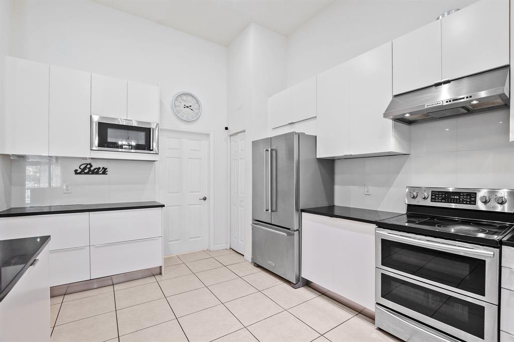 816 West Village Circle, Unit 1 Davie, FL 33325 - Photo 5 of 27 a kitchen with granite countertop a refrigerator and a stove