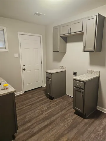 a utility room with wooden floor washer and dryer