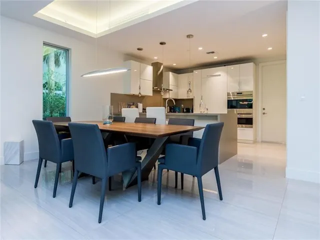 a dining room with a table chairs and a kitchen view