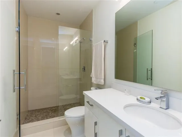 a bathroom with a sink a toilet and shower