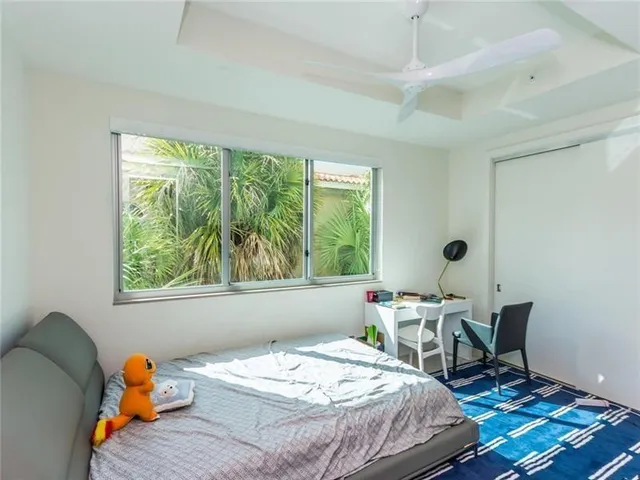 a bedroom with a bed a table and a window