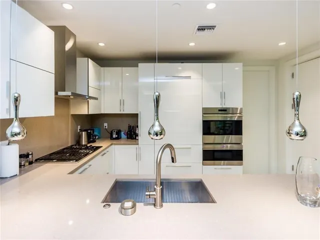 a kitchen with granite countertop a refrigerator and a stove top oven