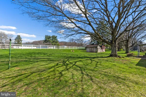 a green field with lots of trees in the background