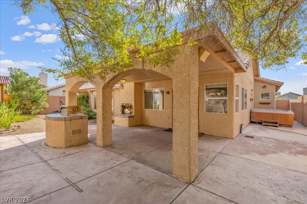120 Ringlore Road Henderson, NV 89015 - Photo 28 of 58 An inviting covered patio offers custom concrete flooring, an outdoor fireplace, and integrated grilling station.