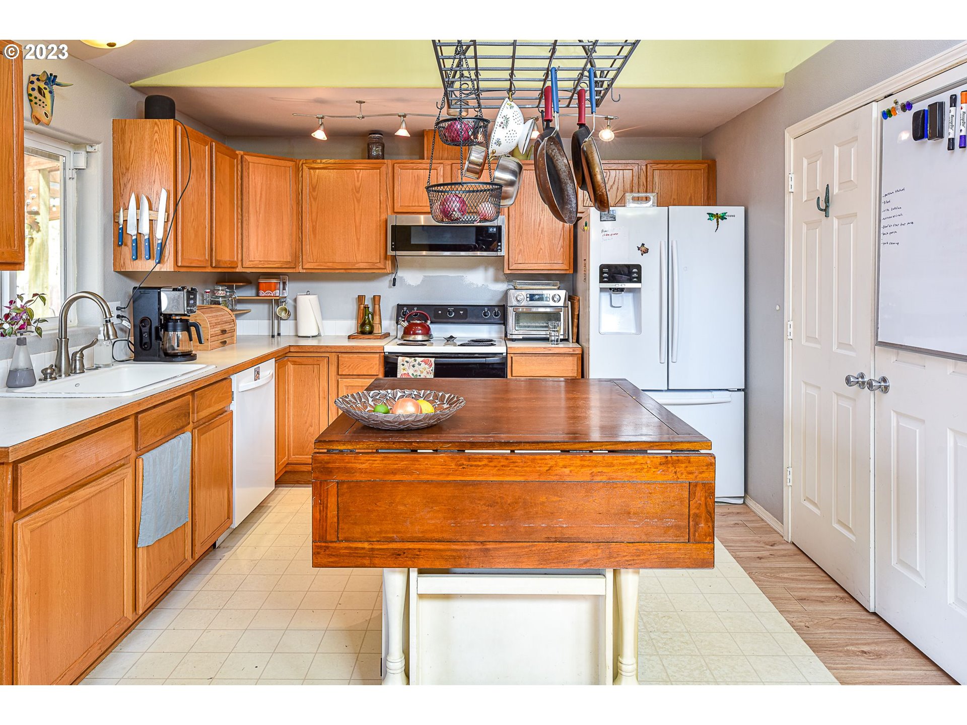 1161 Ash Grove Loop Creswell, OR 97426 - Photo 9 of 22 a view of a kitchen with kitchen island a sink a stove and a refrigerator