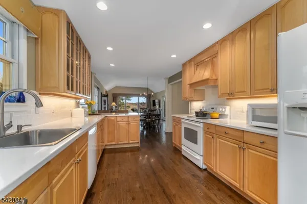 a kitchen with granite countertop a sink a counter top space stainless steel appliances and cabinets