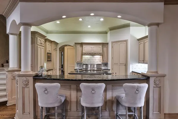 a kitchen with stainless steel appliances kitchen island granite countertop a table and chairs