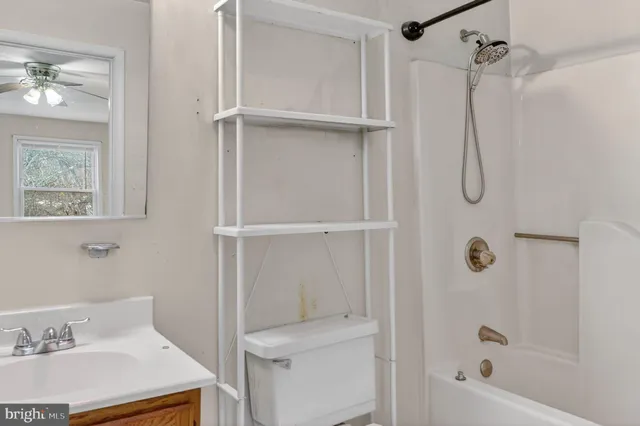 a bathroom with a granite countertop sink a toilet and shower