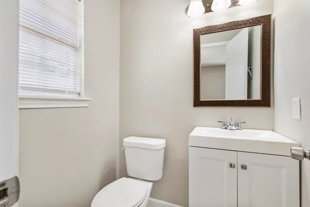 a bathroom with a toilet sink and mirror