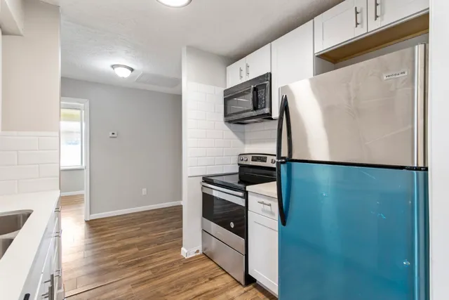 a kitchen with stainless steel appliances a microwave a sink and a refrigerator