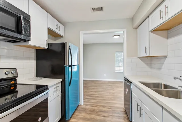 a kitchen with granite countertop a refrigerator and a sink