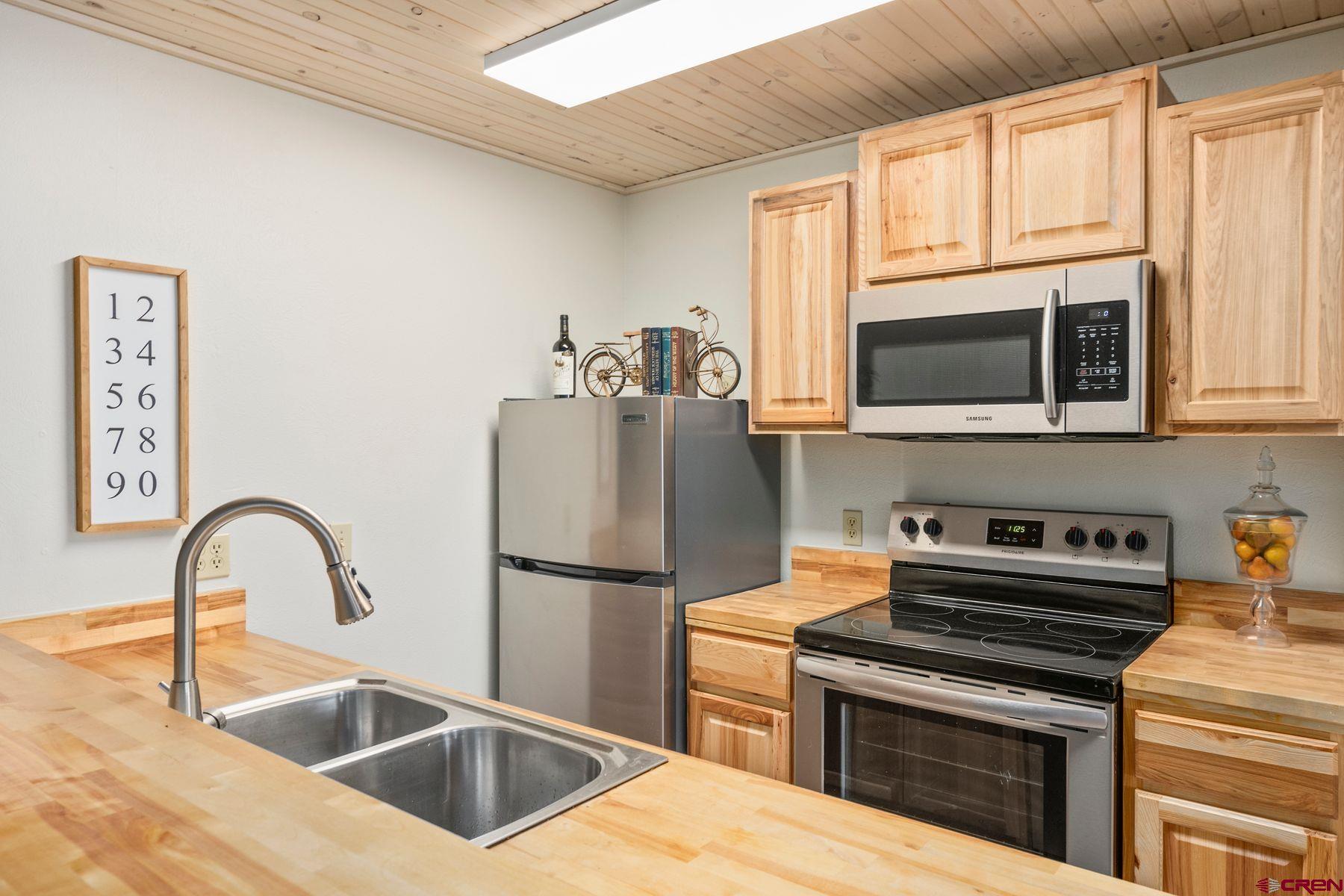 35 Emmons Road, Unit A Crested Butte, CO 81225 - Photo 4 of 28 a kitchen with stainless steel appliances kitchen island a stove a sink and a microwave
