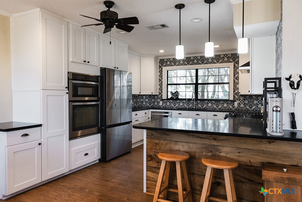 1439 Dagg Road Yoakum, TX 77995 - Photo 11 of 48 a kitchen with stainless steel appliances granite countertop a stove a refrigerator and a sink