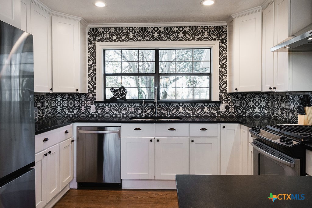 1439 Dagg Road Yoakum, TX 77995 - Photo 12 of 48 a kitchen with granite countertop a sink window and cabinets