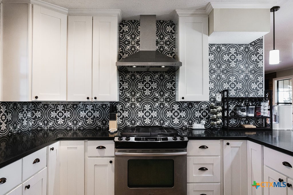 1439 Dagg Road Yoakum, TX 77995 - Photo 13 of 48 a kitchen with stainless steel appliances a stove and white cabinets