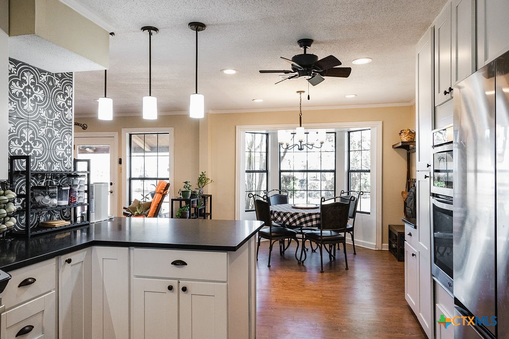 1439 Dagg Road Yoakum, TX 77995 - Photo 14 of 48 a kitchen with stainless steel appliances granite countertop a refrigerator a stove and a dining table with wooden floor