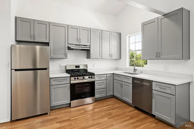 a kitchen with a refrigerator sink and cabinets